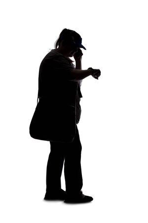 Silhouette of a curvy or plus size woman on a white background.  She is unrecognizable and using a cell phone or smartphoneの写真素材