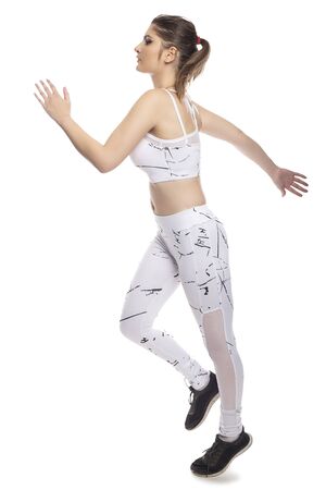 Woman wearing sports clothing running and isolated on white background for composites.  She is an active and fit Caucasian female who looks like she is exercising or practicingの写真素材