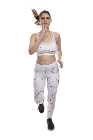 Woman wearing sports clothing running and isolated on white background for composites.  She is an active and fit Caucasian female who looks like she is exercising or practicingの写真素材
