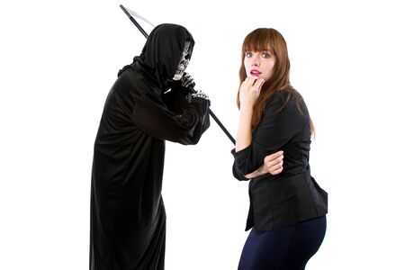 Scared businesswoman paranoid of catching a deadly disease represented by the grim reaper.  She is frightened of contracting a pandemic illness such as coronavirusの写真素材