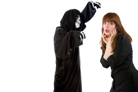 Scared businesswoman paranoid of catching a deadly disease represented by the grim reaper.  She is frightened of contracting a pandemic illness such as coronavirusの写真素材