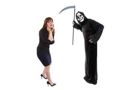 Scared businesswoman paranoid of catching a deadly disease represented by the grim reaper.  She is frightened of contracting a pandemic illness such as coronavirusの写真素材