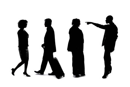 Silhouettes of a group of workers depicting a company or networking event.  The businessmen and businesswomen are unrecognizable and anonymous and represents an office team or staff.の写真素材