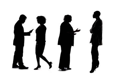 Silhouettes of a group of workers depicting a company or networking event.  The businessmen and businesswomen are unrecognizable and anonymous and represents an office team or staff.の写真素材