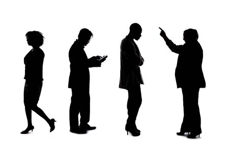 Silhouettes of a group of workers depicting a company or networking event.  The businessmen and businesswomen are unrecognizable and anonymous and represents an office team or staff.の写真素材