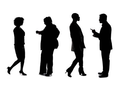 Silhouettes of a group of workers depicting a company or networking event.  The businessmen and businesswomen are unrecognizable and anonymous and represents an office team or staff.の写真素材