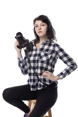Young female art student holding a dslr camera and studying to be a professional or amateur photographer.  She looks creative and inspired to become a photo journalistの写真素材