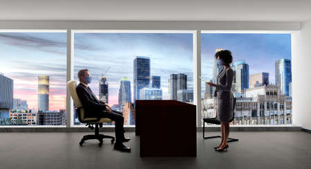 Businessman and businesswoman working in the office during a pandemic and keeping social distance and wearing protective face masks to prevent viral infection of covidの写真素材