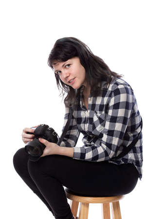 Young female freelance professional photographer or art student or photojournalist on a white background holding a camera. Looking depressed and lack of self confidenceの写真素材