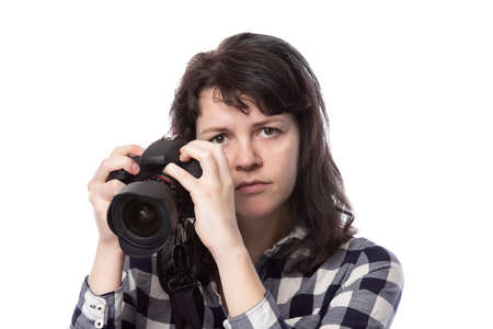 Young female freelance professional photographer or art student or photojournalist on a white background holding a camera. She looks angry and frustratedの写真素材