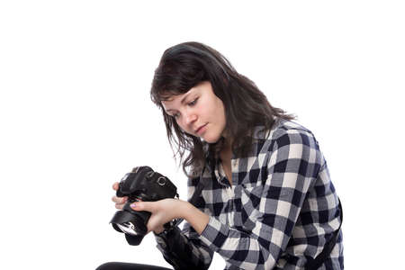 Young female freelance professional photographer or art student or photojournalist on a white background holding a camera. Looking depressed and lack of self confidenceの写真素材