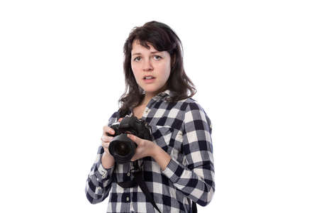 Young female freelance professional photographer or art student or photojournalist on a white background holding a camera with thumbs downの写真素材