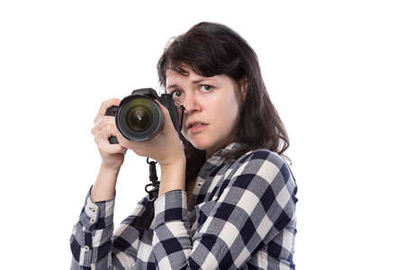 Young female freelance professional photographer or art student or photojournalist on a white background holding a camera with thumbs downの写真素材