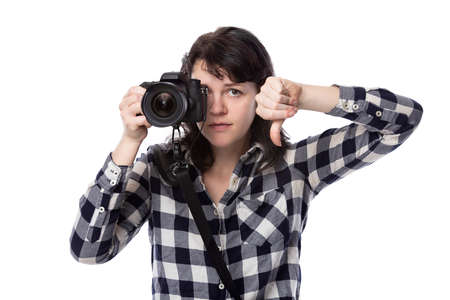 Young female freelance professional photographer or art student or photojournalist on a white background holding a camera. She is feeling sick or unwellの写真素材