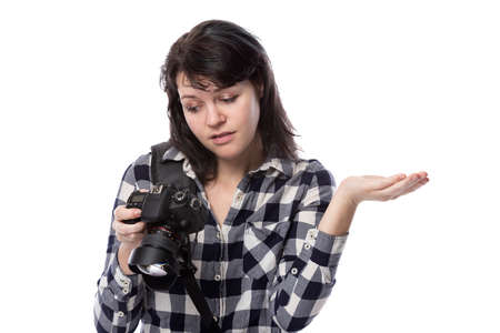 Young female freelance professional photographer or art student or photojournalist on a white background holding a camera. She is feeling sick or unwellの写真素材