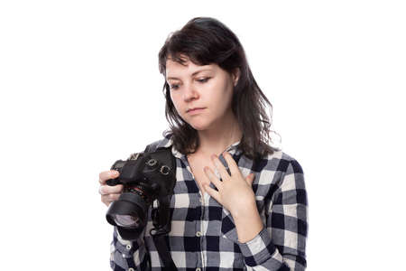 Young female freelance professional photographer or art student or photojournalist on a white background holding a camera. She is feeling sick or unwellの写真素材