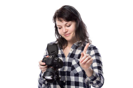 Young female freelance professional photographer or art student or photojournalist on a white background holding a camera. She is feeling sick or unwellの写真素材