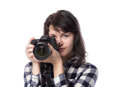 Young female freelance professional photographer or art student or photojournalist on a white background holding a camera. She looks worried of mistakesの写真素材