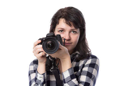 Young female freelance professional photographer or art student or photojournalist on a white background holding a camera. She looks worried of mistakesの写真素材