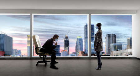 Businessman and businesswoman working in the office during a pandemic and keeping social distance and wearing protective face masks to prevent viral infection of covidの写真素材