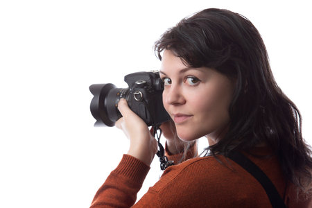 Side view of a female photographer holding a camera isolated on a white background for composites.  The model is posed to face a scenery or copy spaceの写真素材