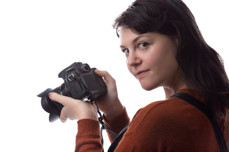 Side view of a female photographer holding a camera isolated on a white background for composites.  The model is posed to face a scenery or copy spaceの写真素材