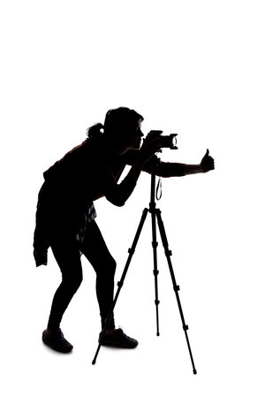 Silhouette of a photographer with a camera on a white background isolated for composites. She is posed with a thumbs up gestureの写真素材