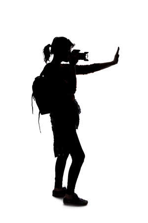 Silhouette of a photographer with a camera on a white background isolated for composites.  She is posed with a stop gestureの写真素材