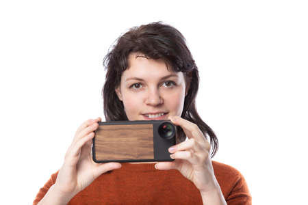 Female tourist or photographer doing mobile photography with a cell phone as an alternative equipment for hobby.  The camera phone is smaller and lighter than a traditional dslrの写真素材