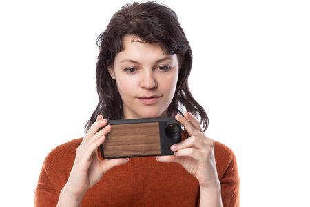 Female tourist or photographer doing mobile photography with a cell phone as an alternative equipment for hobby.  The camera phone is smaller and lighter than a traditional dslrの写真素材