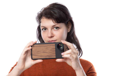 Female tourist or photographer doing mobile photography with a cell phone as an alternative equipment for hobby.  The camera phone is smaller and lighter than a traditional dslrの写真素材