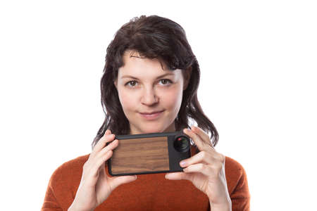 Female tourist or photographer doing mobile photography with a cell phone as an alternative equipment for hobby.  The camera phone is smaller and lighter than a traditional dslrの写真素材