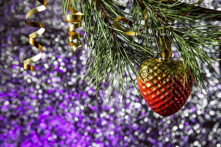 pine branch with Christmas toy on the bright glowing backgroundの写真素材