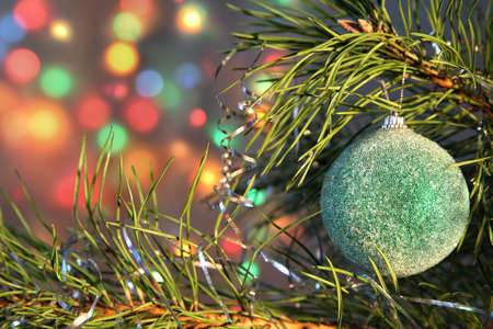 pine branch with Christmas ball on the bright glowing backgroundの写真素材