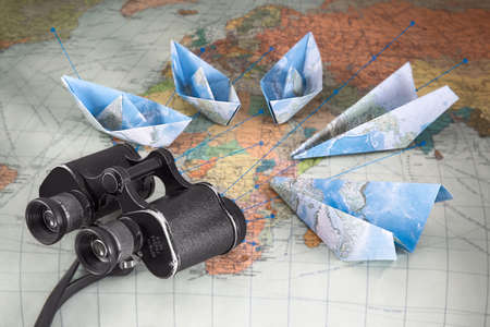 Travel. Paper plane and a paper ship, geographical map, binocularsの写真素材