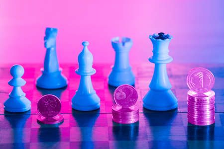Chess pieces and stacks of coins on bright background. Concept for success and financial growth.の写真素材