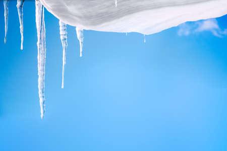 Snow hanging from above, icicles, sky backgroundの写真素材