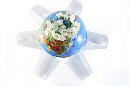 Planet Earth has flowers and used plastic cups. Isolated white background.の写真素材