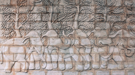 Elephant sculpture on the brown sandstone wall in thailandの写真素材