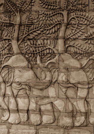 elephant sculpture on the brown sandstone wall in thailandの写真素材