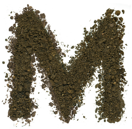 Alphabet made of brown soil on white background. High sharp and detail. Letter Mの写真素材