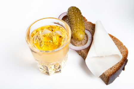 Russian vodka in small glass with black bread, pickled, onion and bit of lard on white backgroundの写真素材
