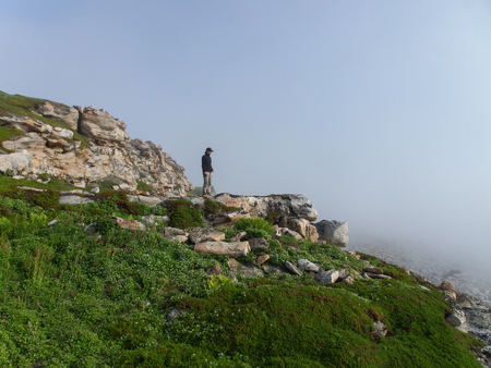Tourist on a mountain slope in the fogの写真素材