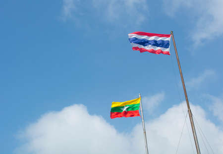 waving Thailand flag and Myanmar flagの写真素材