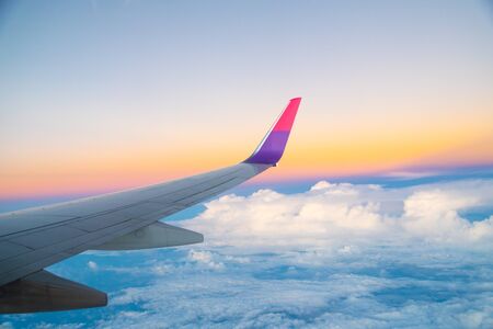 Airplane Wing in Flight from window, sunset sky, twilight skyの写真素材