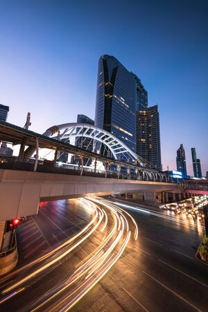 Lights up at night shows the architectural design of the skywalk above the intersection on Sathorn road in bustling Bangkok, Thailandのeditorial素材