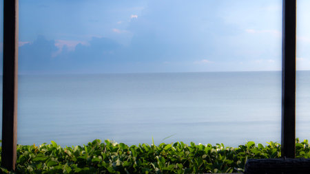 Sea view from the window of a villa at sunset in the tropicsの写真素材