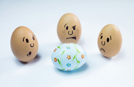 Egg faces are around an easter egg.の写真素材