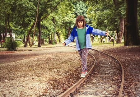 A little girl balancing on the rails.の写真素材