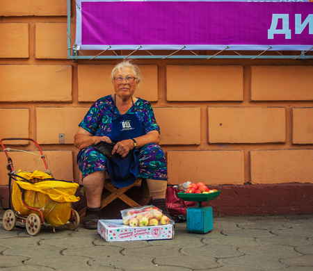 Orenburg, Russia - August 16, 2017: an old woman is selling fruit on the street.のeditorial素材